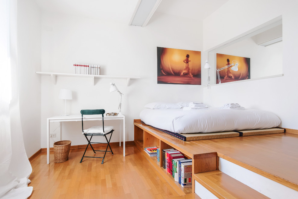 Modernes Hauptschlafzimmer mit weißer Wandfarbe und braunem Holzboden in Mailand