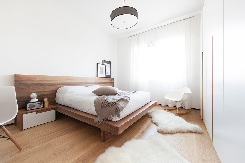 На фото: хозяйская спальня среднего размера в современном стиле с белыми стенами и паркетным полом среднего тона