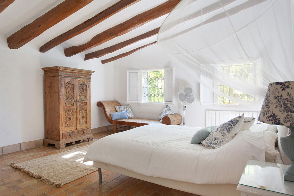 フィレンツェにある広いカントリー風のおしゃれな主寝室 (白い壁、レンガの床) のインテリア