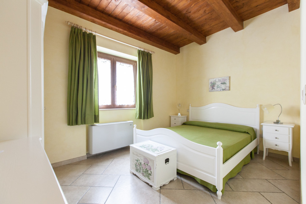 Foto di una camera da letto classica di medie dimensioni con pareti gialle e pavimento beige