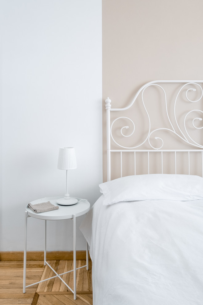 Imagen de habitación de invitados contemporánea pequeña con paredes blancas, suelo de madera clara y suelo beige