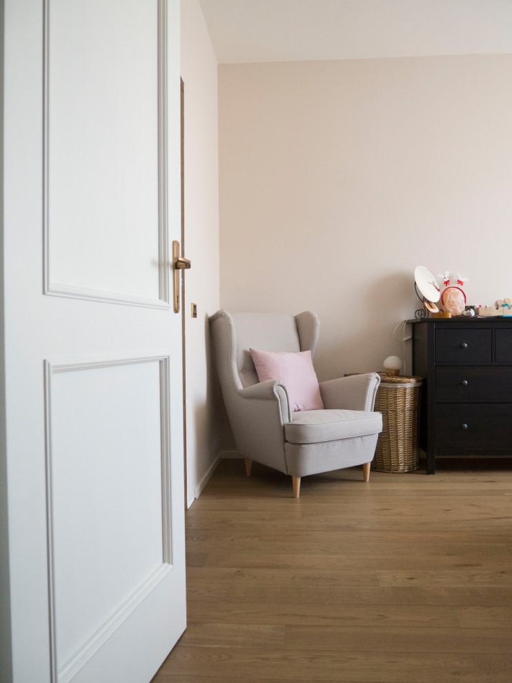 Aménagement d'une grande chambre parentale contemporaine avec un mur rose et un sol en bois brun.