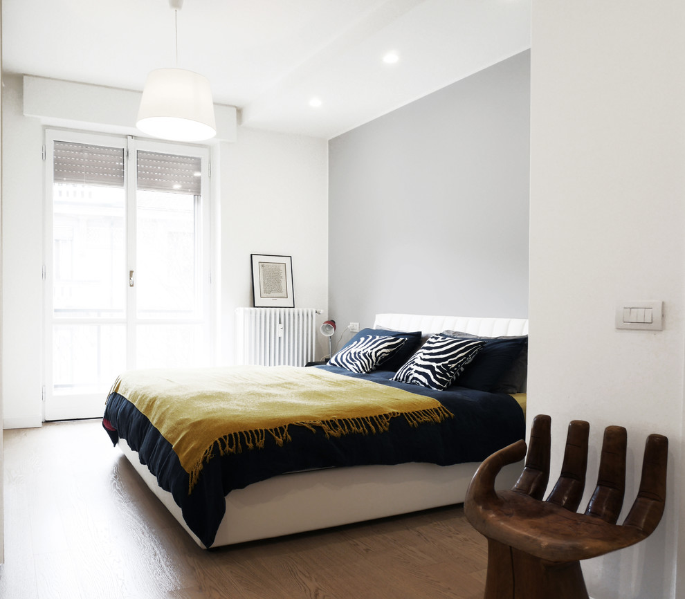 Foto di una camera matrimoniale minimalista di medie dimensioni con pareti bianche, parquet chiaro e pavimento beige