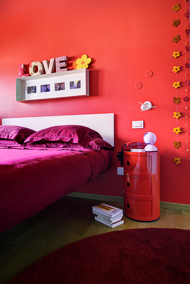 Esempio di una camera da letto con pareti rosse