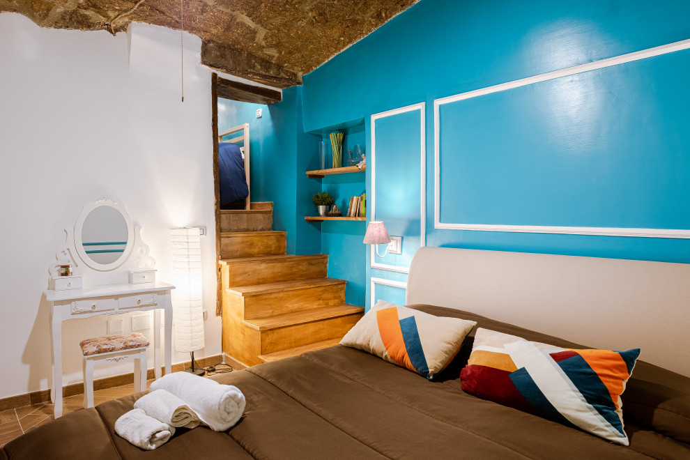 Idée de décoration pour une petite chambre parentale bohème avec un mur bleu, un sol en carrelage de porcelaine et un sol bleu.