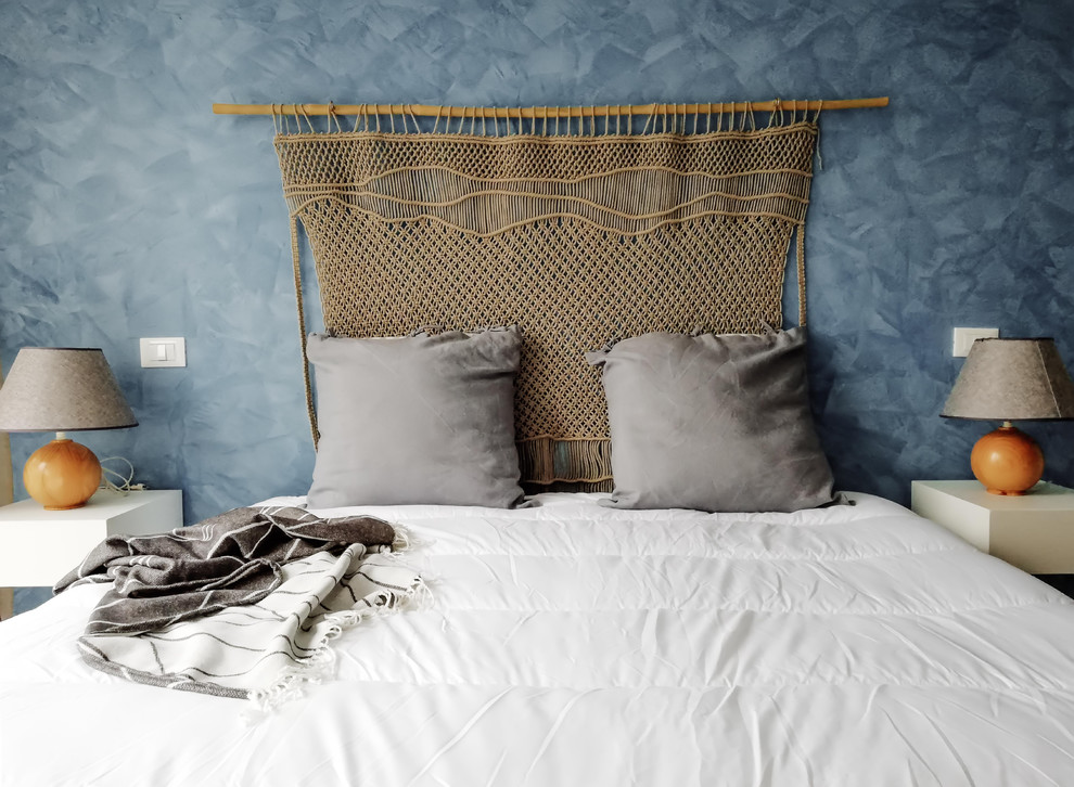 Imagen de dormitorio principal marinero de tamaño medio con paredes azules, suelo de mármol y suelo rosa
