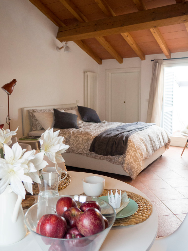 Modelo de dormitorio principal nórdico pequeño con paredes blancas, suelo de baldosas de terracota y suelo rojo