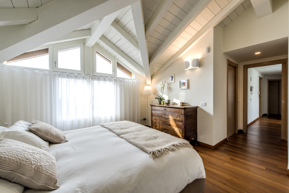 Immagine di un'ampia camera matrimoniale moderna con pareti bianche, pavimento in legno massello medio e pavimento marrone
