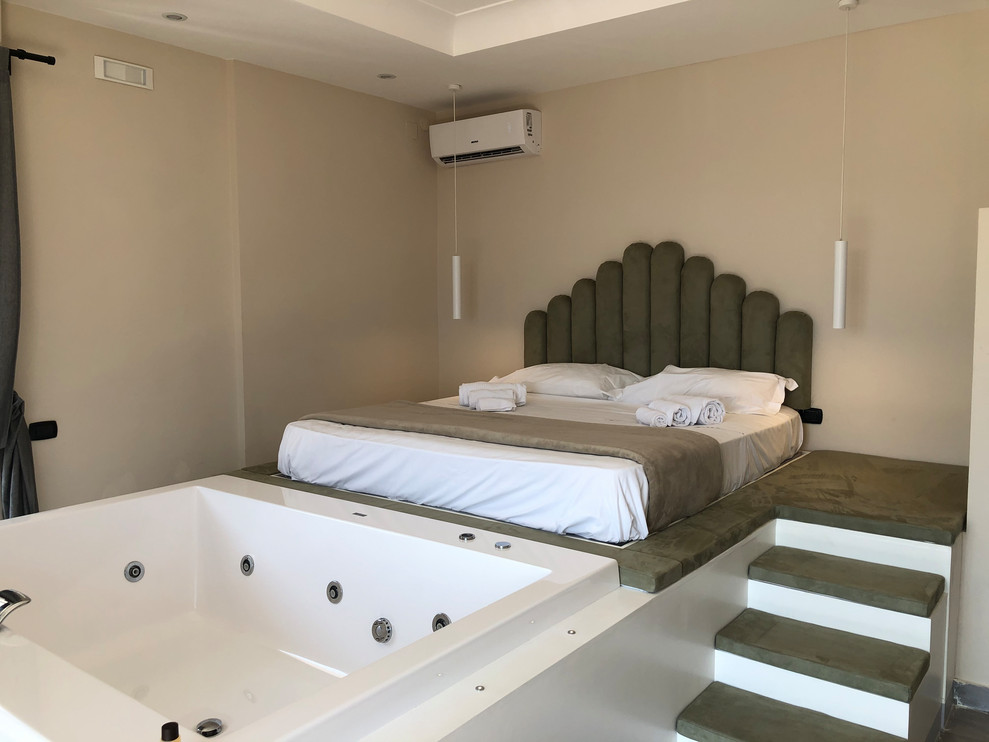 Foto di una grande camera da letto stile loft mediterranea con pareti beige, pavimento in legno verniciato e pavimento bianco