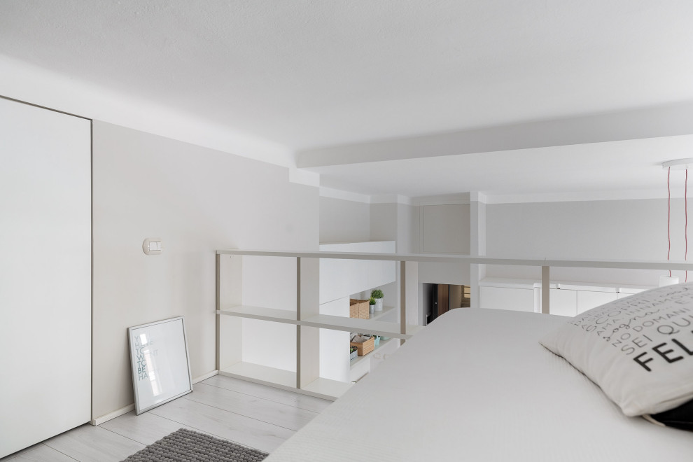 Small danish loft-style laminate floor and beige floor bedroom photo in Milan with gray walls
