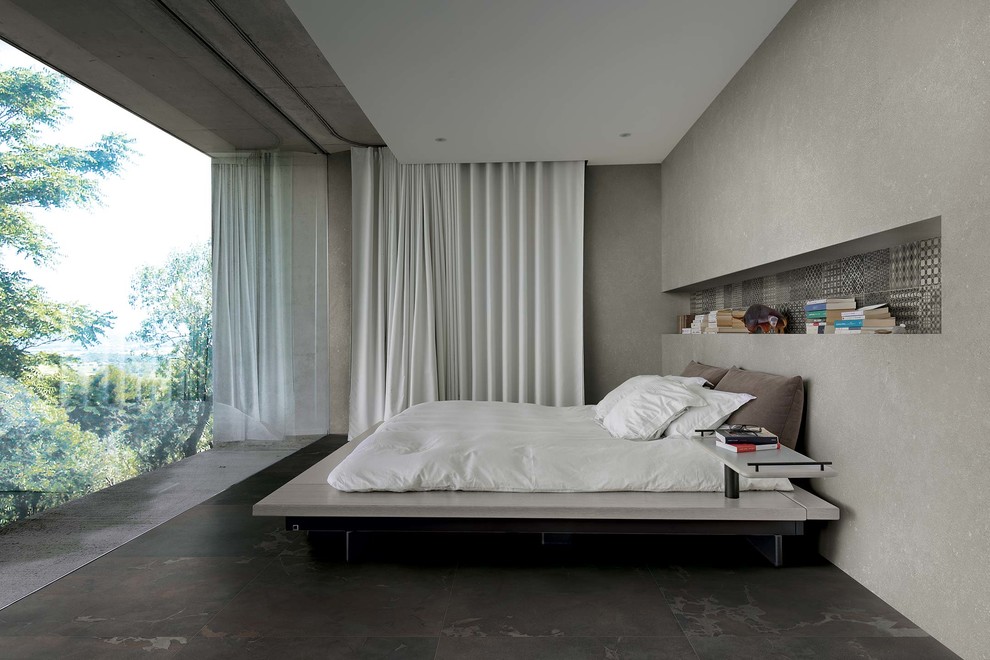 Design ideas for a large contemporary master bedroom in Florence with beige walls, porcelain flooring and brown floors.