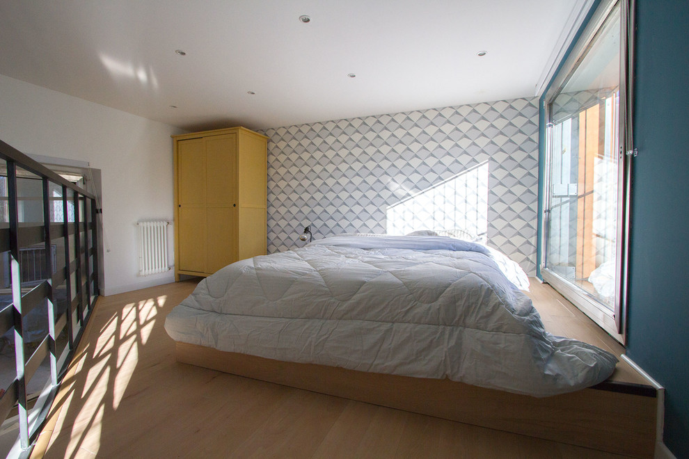 Imagen de dormitorio tipo loft actual pequeño con paredes multicolor y suelo de madera en tonos medios