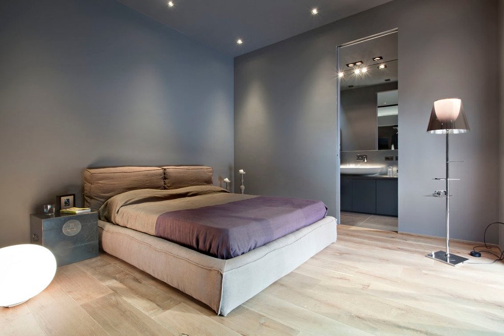 ミラノにある広いコンテンポラリースタイルのおしゃれな主寝室 (グレーの壁、淡色無垢フローリング、照明) のレイアウト
