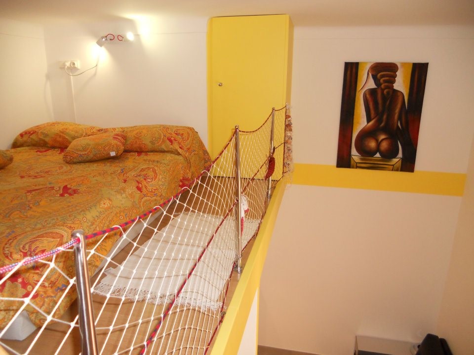 Exempel på ett litet eklektiskt sovloft, med flerfärgade väggar och ljust trägolv
