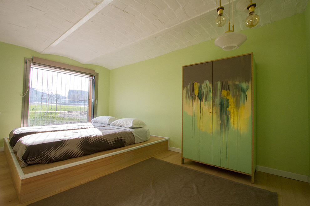 Ispirazione per una camera matrimoniale minimal di medie dimensioni con pareti verdi, pavimento beige e pavimento in legno massello medio