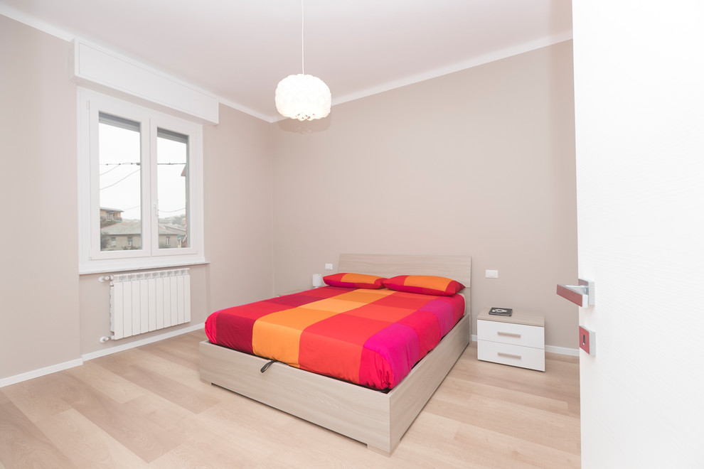 Immagine di una camera da letto design di medie dimensioni con pareti grigie, pavimento in laminato e pavimento marrone