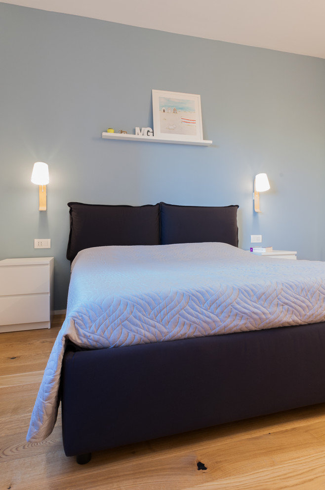 Idee per una camera matrimoniale design di medie dimensioni con pareti blu, parquet chiaro e pavimento beige