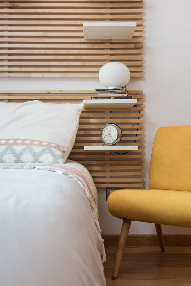 Imagen de dormitorio principal moderno de tamaño medio con paredes blancas y suelo de madera en tonos medios