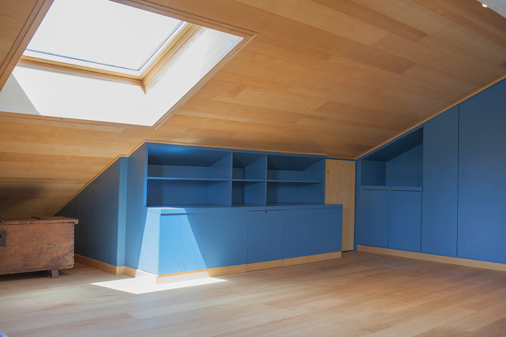 Imagen de dormitorio tipo loft minimalista de tamaño medio con suelo de madera pintada, todas las chimeneas y marco de chimenea de madera