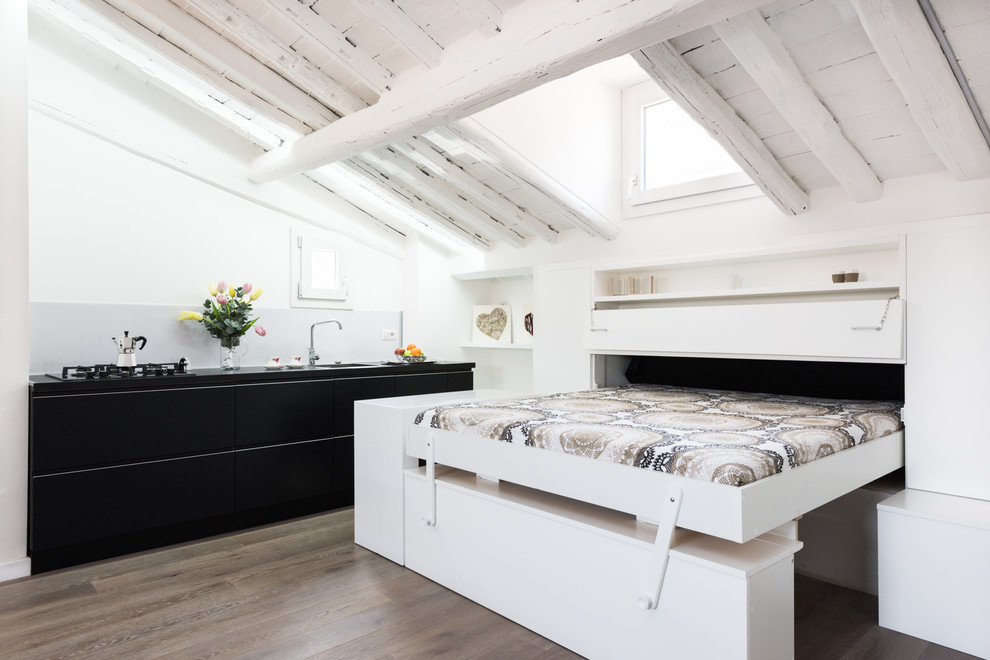 Kleines Modernes Gästezimmer ohne Kamin mit weißer Wandfarbe und hellem Holzboden in Rom