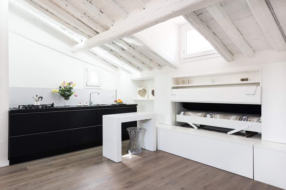 Cette image montre une petite chambre d'amis design avec un mur blanc, parquet clair et aucune cheminée.