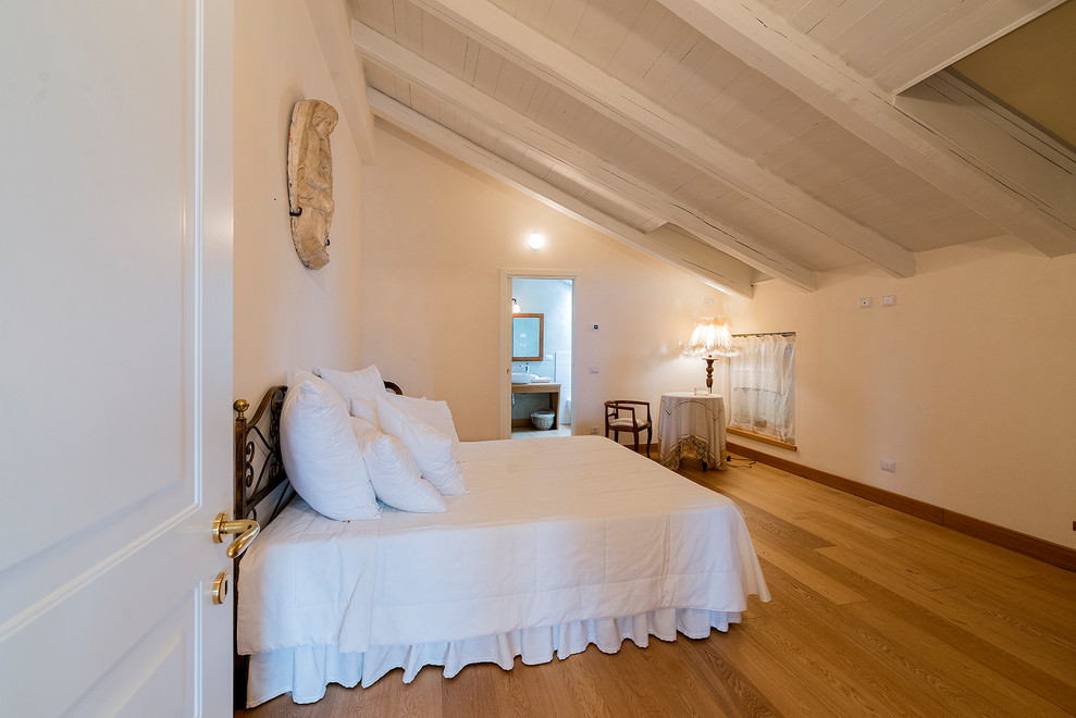 Foto de dormitorio principal romántico grande con paredes blancas y suelo de madera en tonos medios