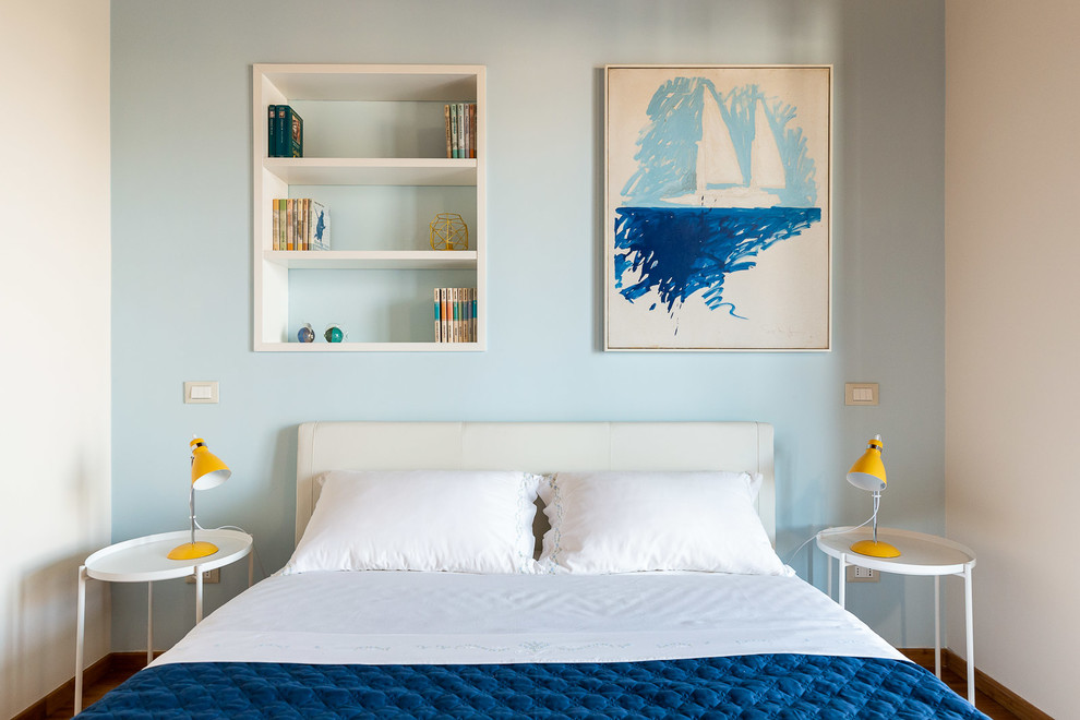 Immagine di una camera matrimoniale minimal di medie dimensioni con pareti blu e parquet chiaro