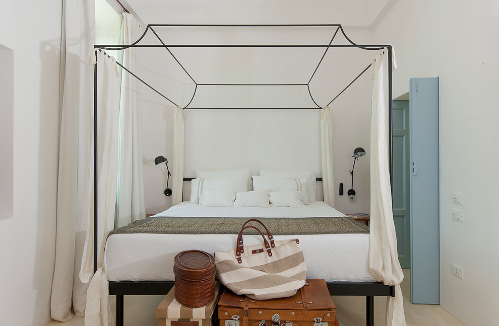 Modelo de dormitorio principal mediterráneo pequeño con paredes blancas y suelo de madera clara