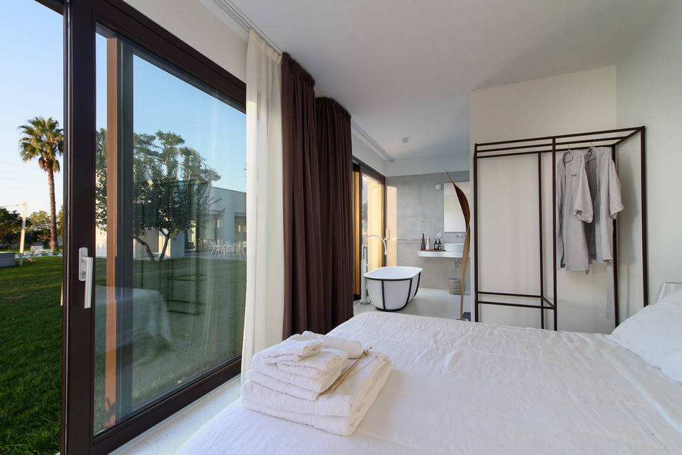 На фото: спальня в стиле модернизм с белыми стенами с