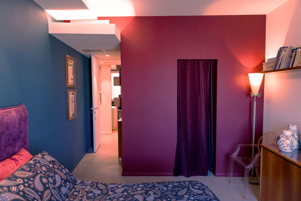 Cette photo montre une grande chambre parentale tendance avec un mur bleu, sol en béton ciré et un sol gris.