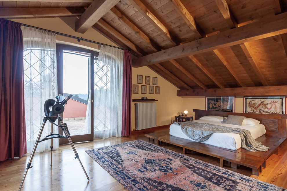 Imagen de dormitorio mediterráneo con paredes beige, suelo de madera en tonos medios y suelo marrón