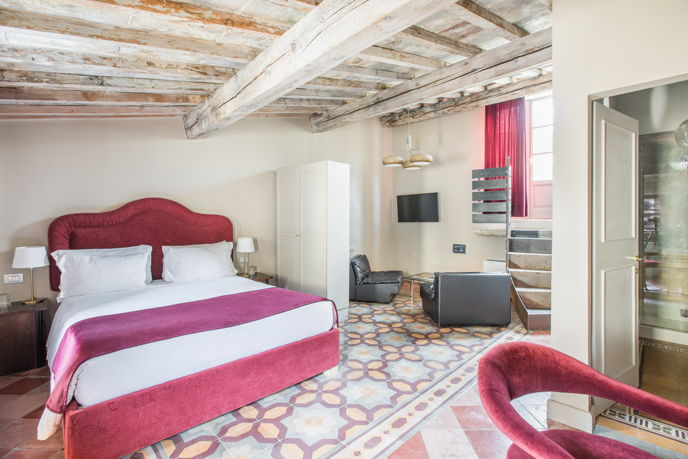 Esempio di una camera da letto mediterranea con pareti beige e pavimento multicolore