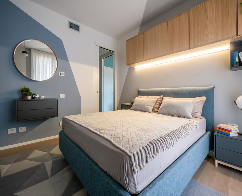 Photo of a small scandinavian master bedroom in Milan with multi-coloured walls and light hardwood flooring.