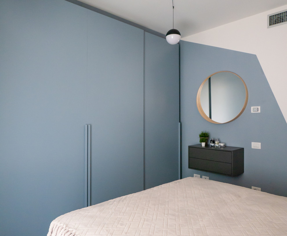 Ejemplo de dormitorio principal nórdico pequeño con paredes multicolor y suelo de madera clara