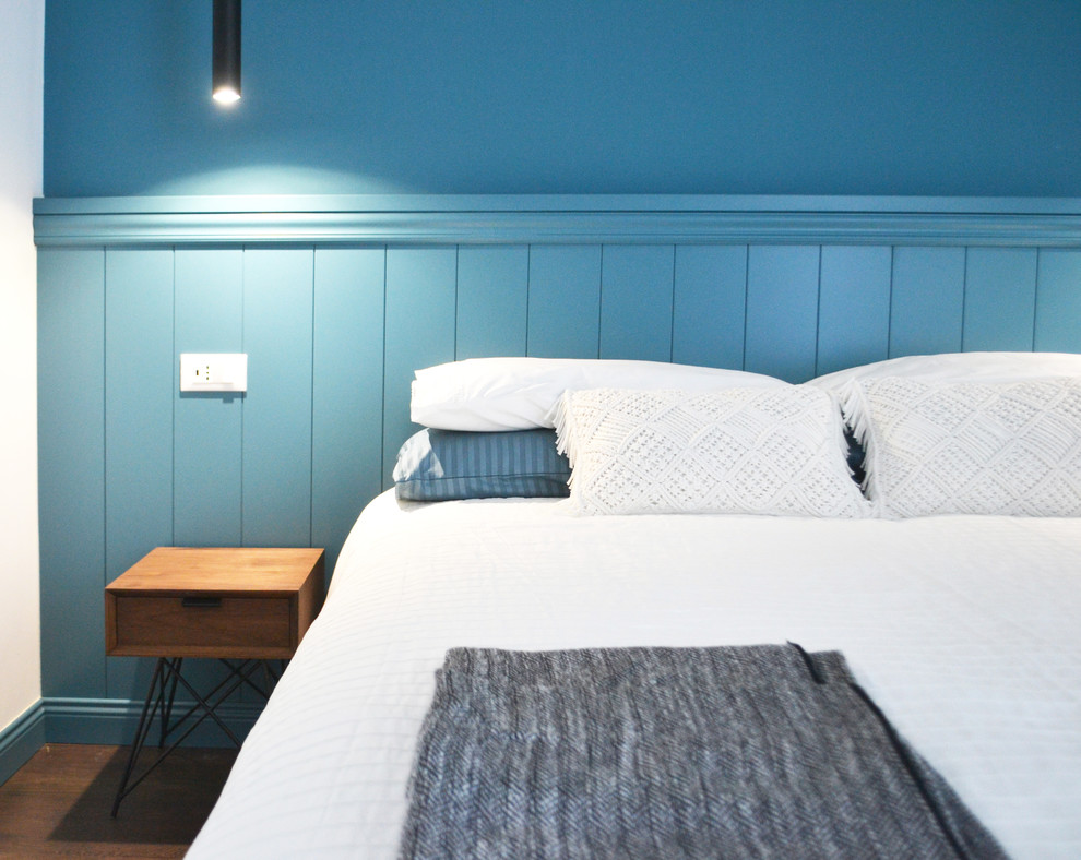 Идея дизайна: хозяйская спальня среднего размера в современном стиле с синими стенами, полом из ламината и коричневым полом