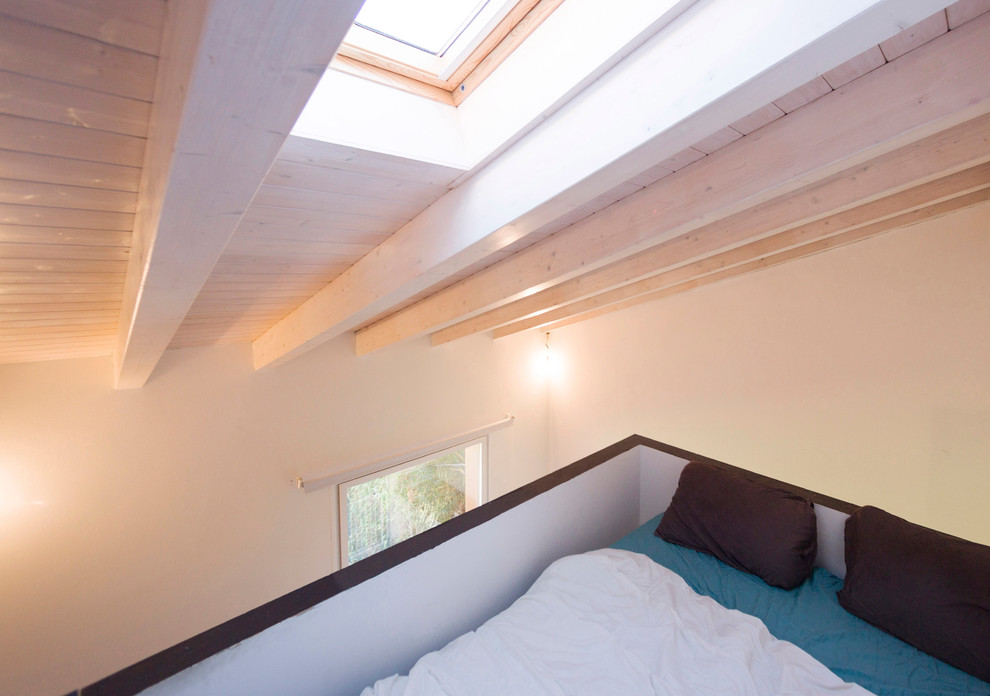 Immagine di una piccola camera da letto stile loft design con pareti bianche e pavimento grigio