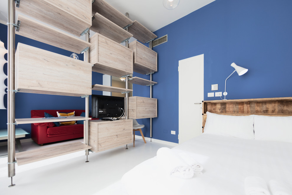 Idées déco pour une petite chambre mansardée ou avec mezzanine contemporaine avec un mur bleu, parquet peint et un sol blanc.