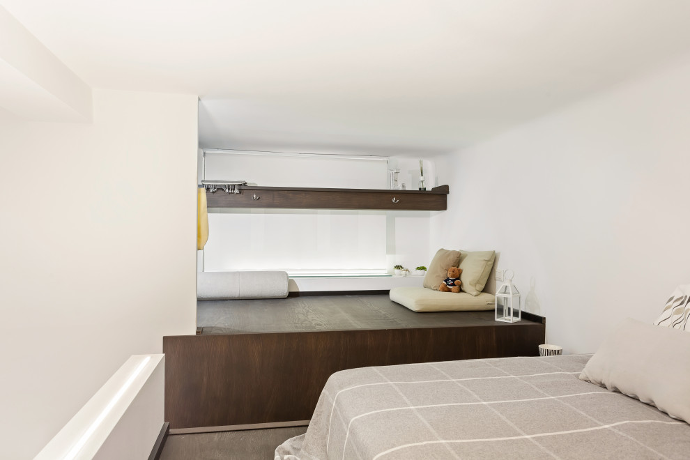 Esempio di una piccola camera da letto stile loft moderna con pareti bianche, parquet scuro e pavimento marrone