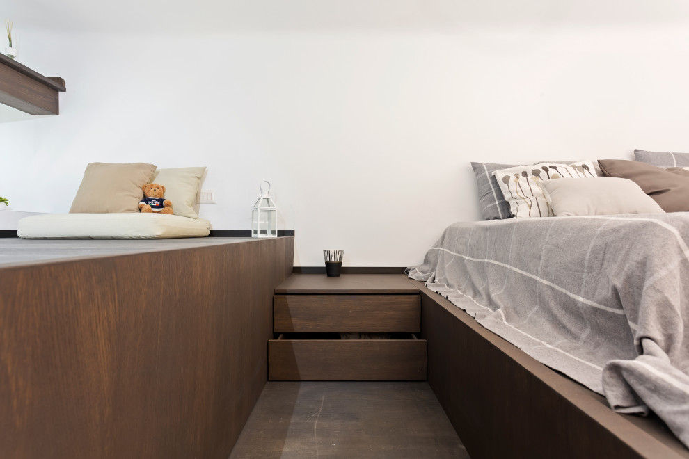 На фото: маленькая спальня на антресоли в стиле модернизм с белыми стенами, темным паркетным полом и коричневым полом для на участке и в саду с