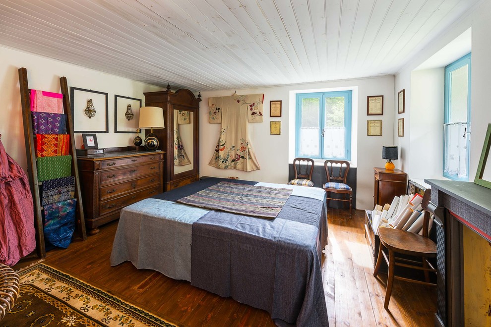 Immagine di una grande camera da letto country con pareti bianche e pavimento in legno massello medio