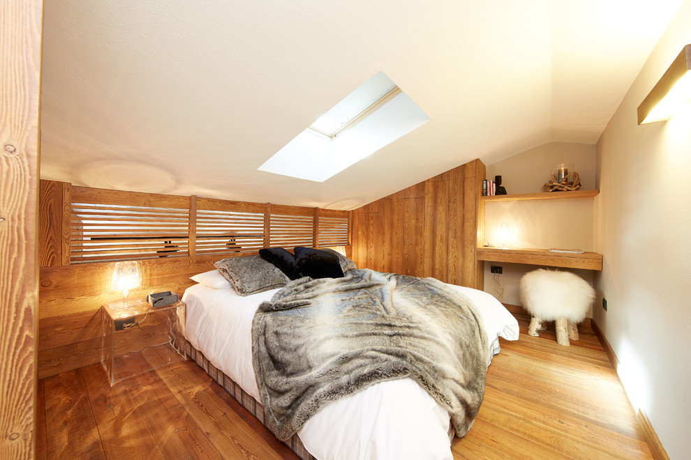 Kleines Uriges Hauptschlafzimmer ohne Kamin mit weißer Wandfarbe und braunem Holzboden in Turin