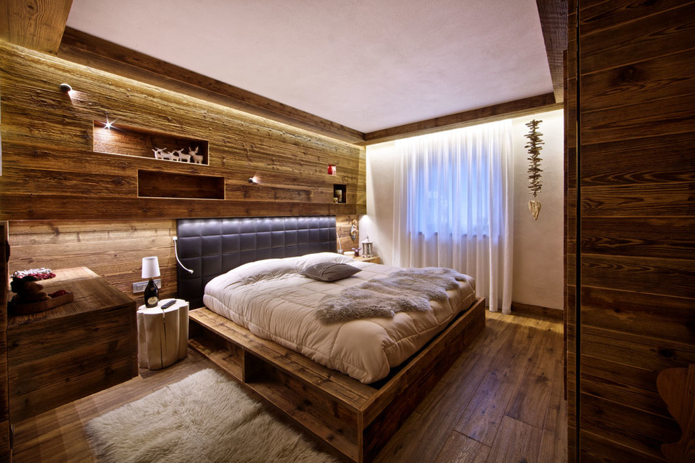 Стильный дизайн: хозяйская спальня среднего размера в стиле рустика с темным паркетным полом, белыми стенами и акцентной стеной - последний тренд