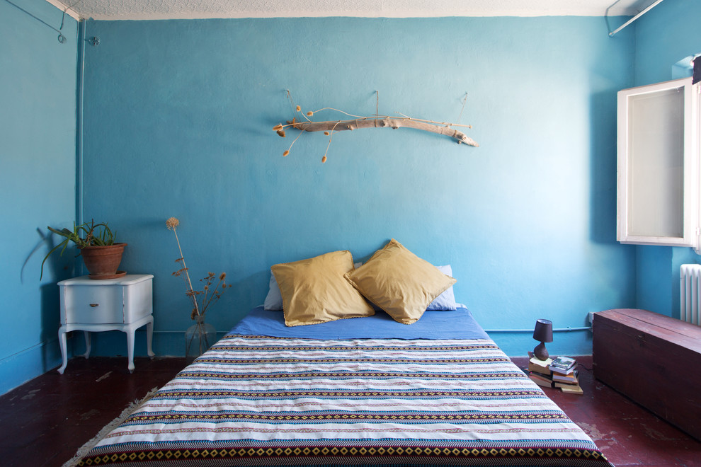 Diseño de dormitorio principal mediterráneo con paredes azules, suelo de baldosas de terracota y suelo rojo