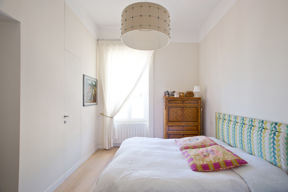 Modelo de dormitorio principal bohemio con paredes blancas y suelo de madera en tonos medios