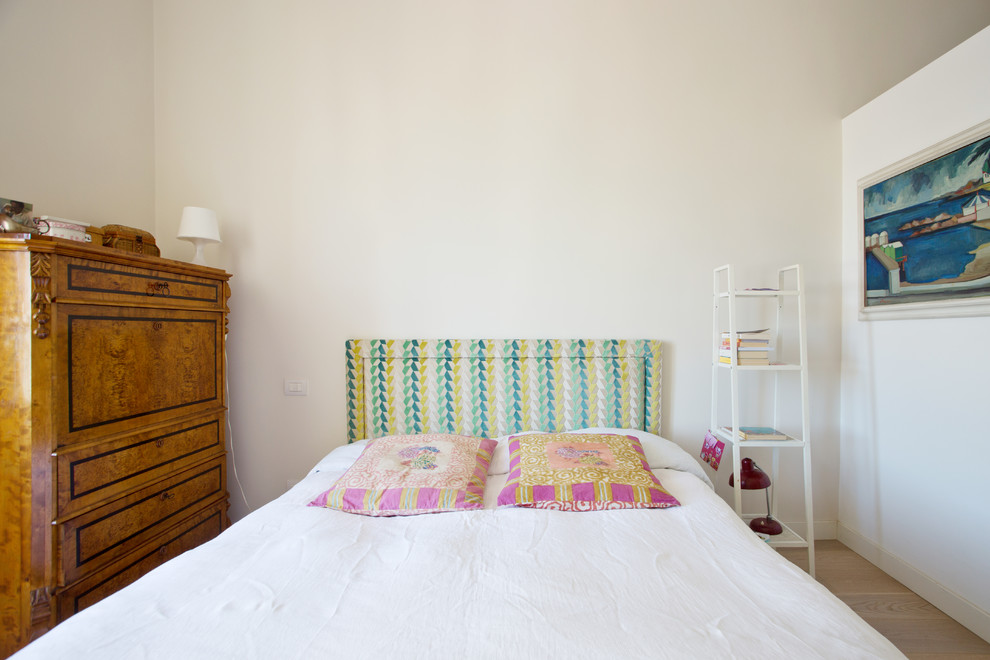Modelo de dormitorio principal ecléctico con paredes blancas y suelo de madera en tonos medios