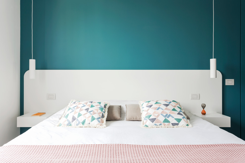 Esempio di una piccola camera matrimoniale minimal con pareti blu e pavimento in legno massello medio