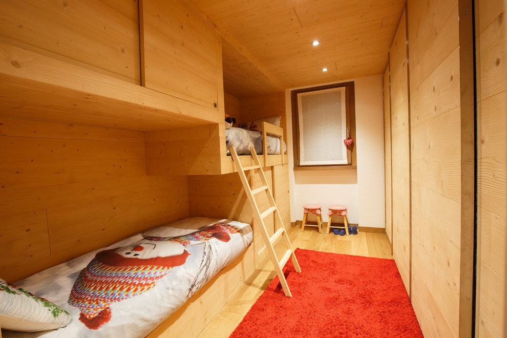 Imagen de habitación de invitados rural pequeña con paredes blancas, suelo de madera en tonos medios y suelo marrón