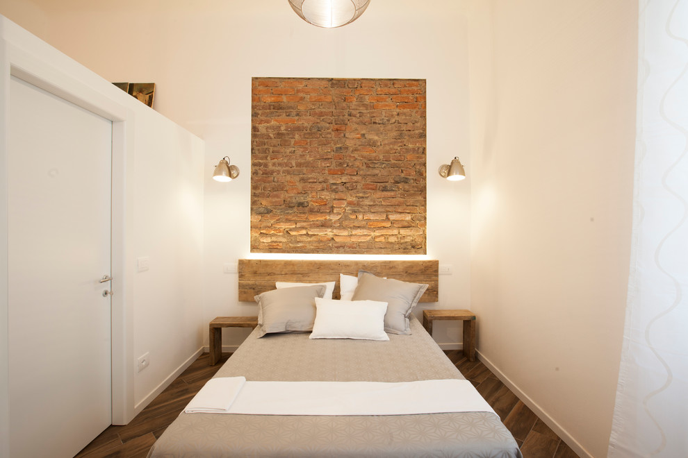 Modelo de dormitorio principal industrial de tamaño medio con paredes blancas, suelo de baldosas de porcelana y suelo marrón