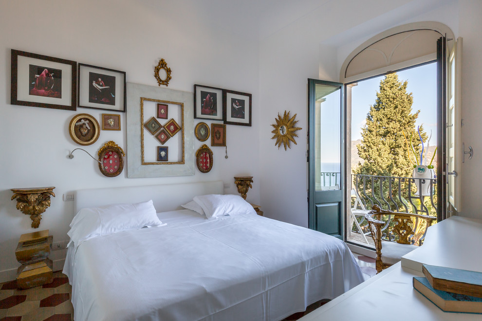 Esempio di una camera da letto mediterranea di medie dimensioni con pareti bianche e pavimento multicolore