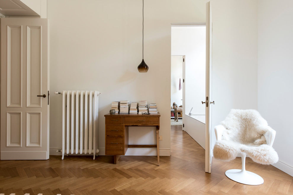 Esempio di una piccola camera da letto contemporanea con pareti bianche e pavimento in legno massello medio